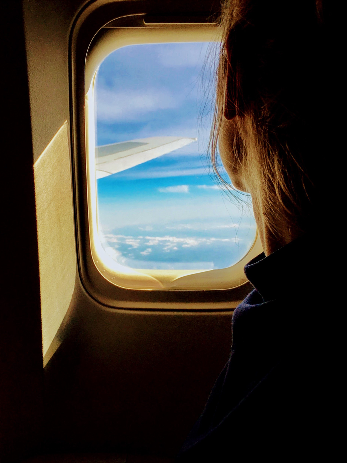 Woman looking out plane window